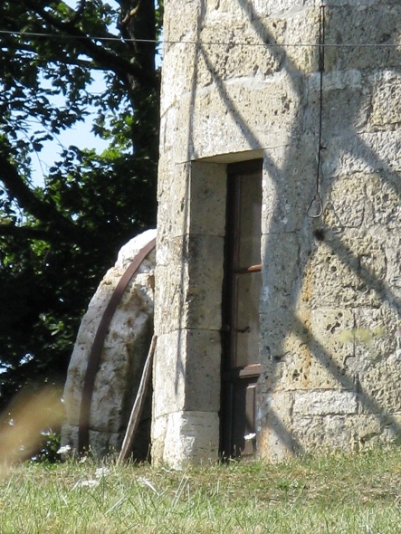 La porte du moulin et l'ancienne meule posée
